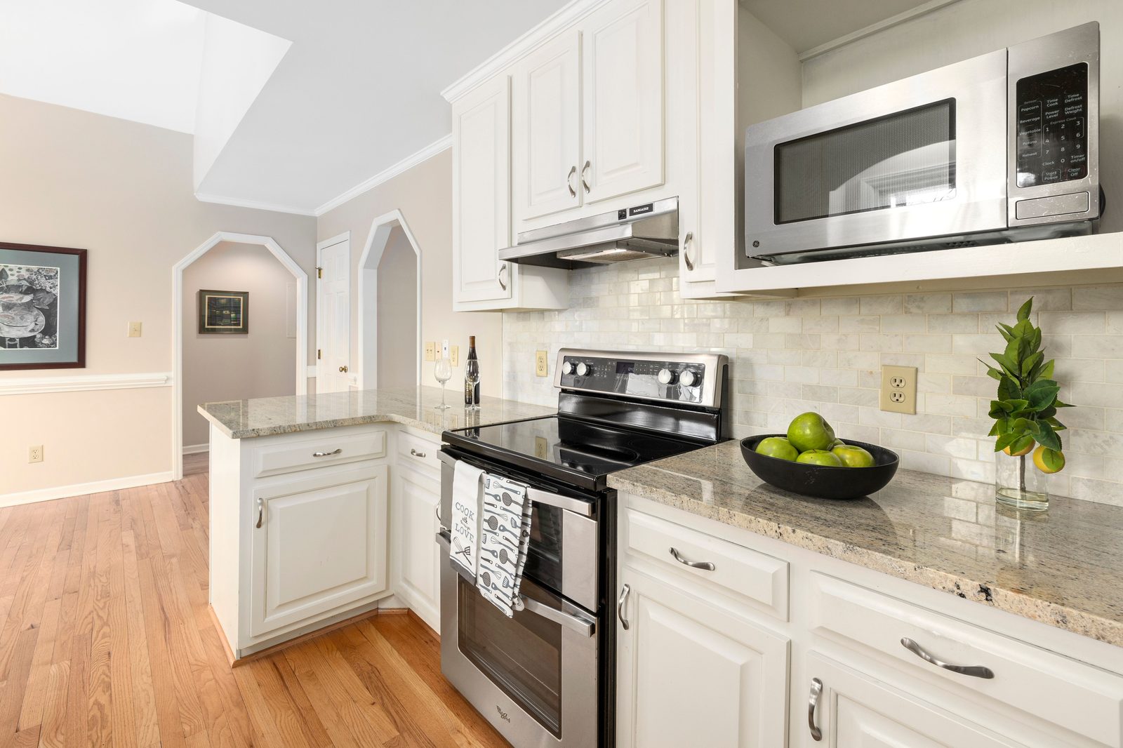 Remodeled kitchen with white shaker cabinets and granite countertops